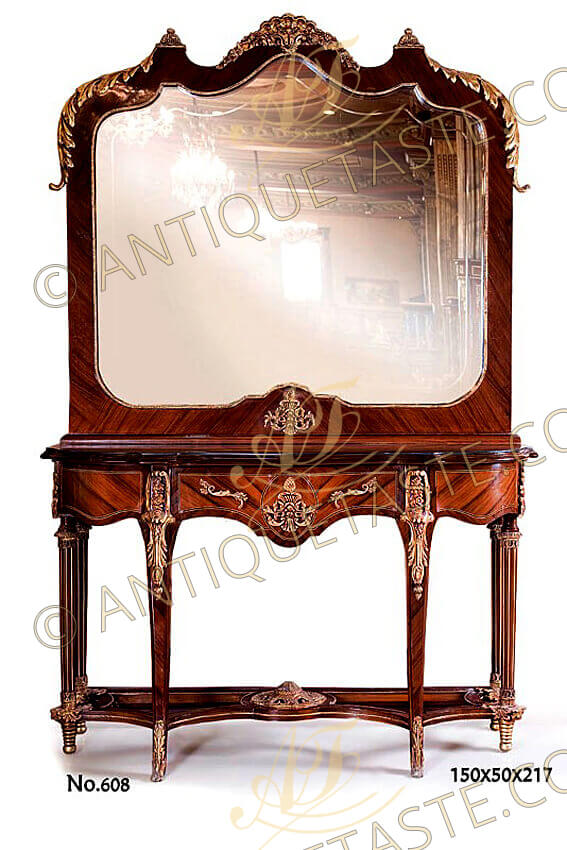 A grandiose French Transitional Louis XV Louis XVI style ormolu-mounted palisander wood veneer inlaid console with matching mirror, The mirror waved top crested with a fine chiseled ormolu foliate shell, flanked with two ormolu acanthus flipped cones and cornered with exquisite large ormolu laurel leaves with turned terminals. The mirror internally framed with a hammered ormolu band and centered at the bottom with a marvelous ormolu mount capuchon of foliage works and acorn finial, The mirror is resting a scalloped shaped eared frieze with a central large drawer ornamented with fine foliate ormolu handled and central capuchon as the above in a sans traverse palisander veneer inlay with filet pattern and flanked with two faux curved drawers, The lower console part is raised on six legs, the front slender tapered capriole legs are astonishingly headed with richly chased ormolu chutes and terminated with delicate foliate ormolu sabots, The side four fluted legs are headed and terminated with foliate ormolu works and resting on ormolu spiral-turned supports, The six legs are joined by a double rounded geometric shaped stretcher centered with a circular pierced ormolu mount and decorated with an ormolu strip